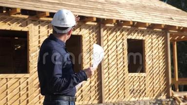 概念建筑构建建筑师慢动作视频.. 戴着头盔的建筑工人站在一座建筑前